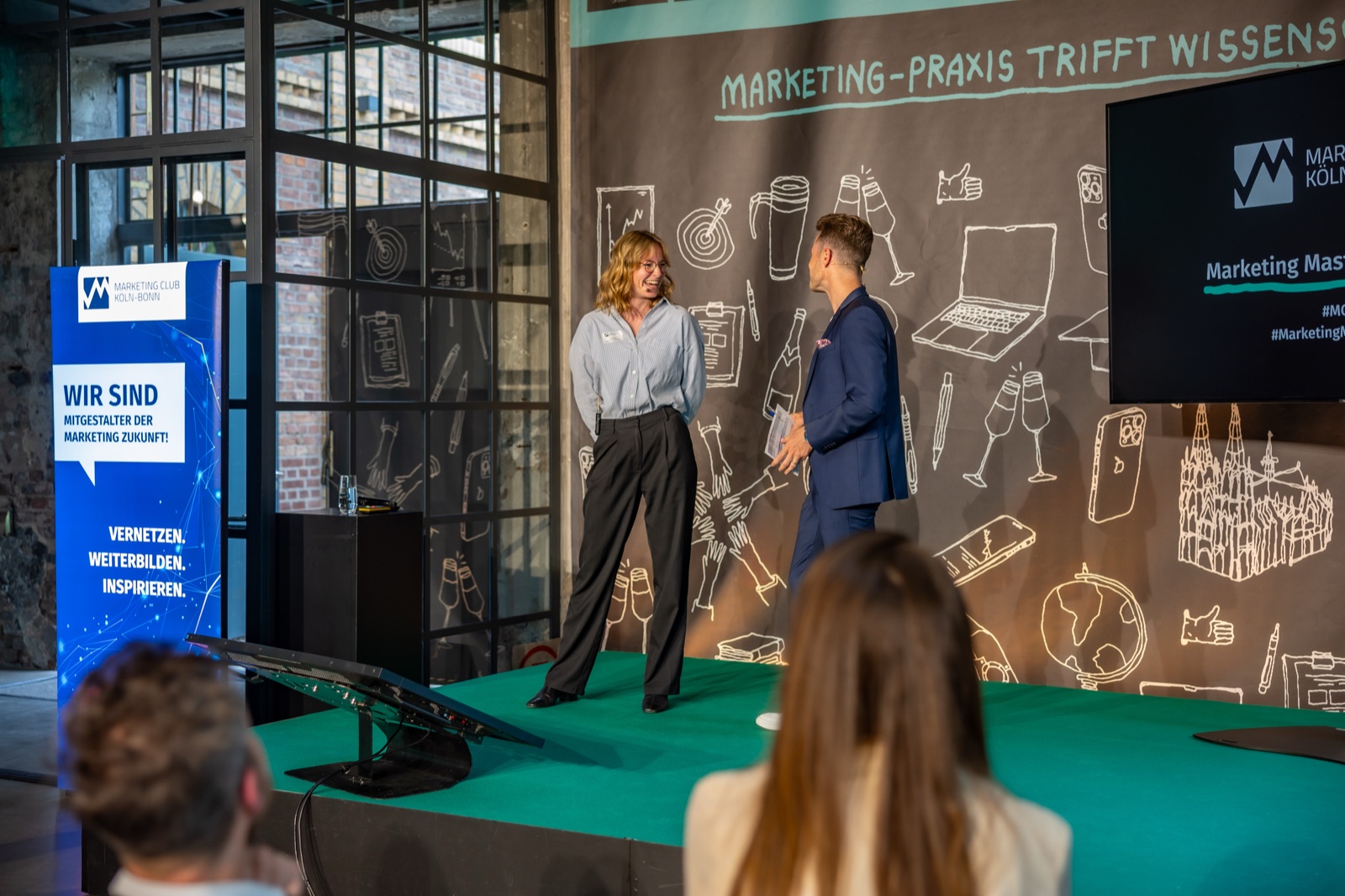 Bühne beim Marketing Master Award mit zwei Sprechenden vor dem Motto Marketing-Praxis trifft Wissenschaft